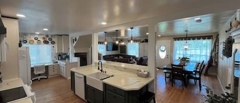 A modern kitchen with a central island, built-in appliances, and a dining area with a table and chairs.