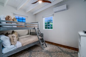 A bunk bed room with a ladder, two windows, and an air conditioning unit. - 5BR Villa w/pool in peaceful residential neighborhood (Charlotte Amalie West)