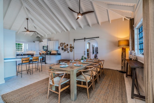 A spacious kitchen with white cabinets, a dining area with wooden chairs, and a ceiling fan. - 5BR Villa w/pool in peaceful residential neighborhood (Charlotte Amalie West)