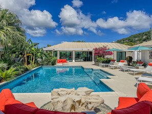 A swimming pool with lounge chairs and a building in the background. - Sunset Sanctuary: Gorgeous 5br w/huge pool/deck & lots of space! (St. Thomas)