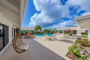 A pool area with lounge chairs, a hanging chair, and a small table. - Sunset Sanctuary: Gorgeous 5br w/huge pool/deck & lots of space! (St. Thomas)