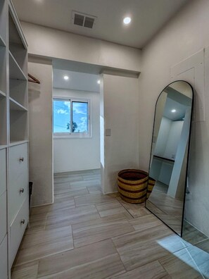A modern room with a large mirror, a window with a view, and a wooden floor. - Sunset Sanctuary: Gorgeous 5br w/huge pool/deck & lots of space! (St. Thomas)