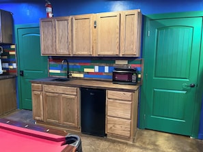 A compact kitchen with wooden cabinets, a microwave, and a dishwasher.