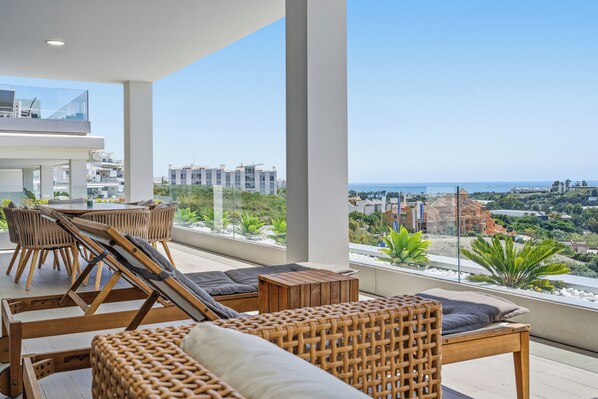 A balcony with wicker furniture, a view of the cityscape, and a clear sky. - Marina Retreat by IIM (Estepona)