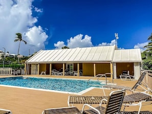 A pool area with lounge chairs, a covered seating area, and a clear blue sky. - Amazing Location & Value! A few steps to the beach, walk to the restaurant/bar! (St. Thomas)