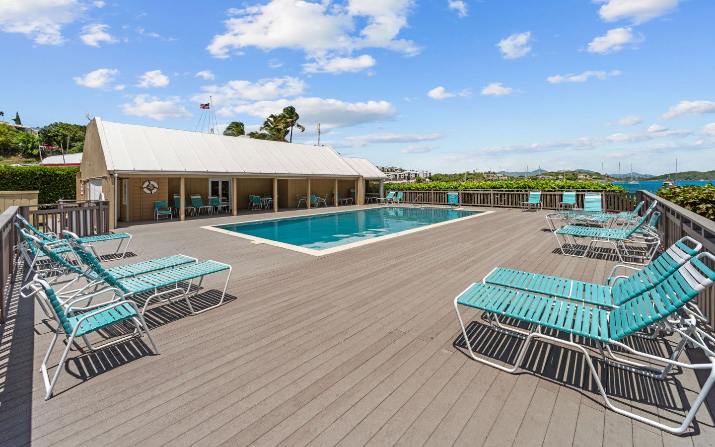 A poolside area with lounge chairs and a pool.