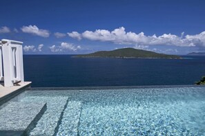 A clear blue sky, a swimming pool with a view of the sea, and a distant island. - Luxury Villa with Infinity Pool Near Magens Bay (St. Thomas)