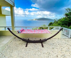 A hammock on a balcony with a view of the sea and a distant island. - Cliff-side 5BR villa - stunning down-island views & 5 mins from Magen`s Bay! (St. Thomas)