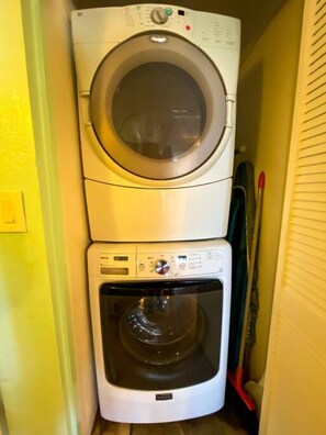 A stacked washer and dryer in a laundry room. - 2BR just steps away from the beach and pool (St. Thomas)