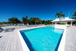 Ein rechteckiger Pool mit umlaufender Holzterrasse.