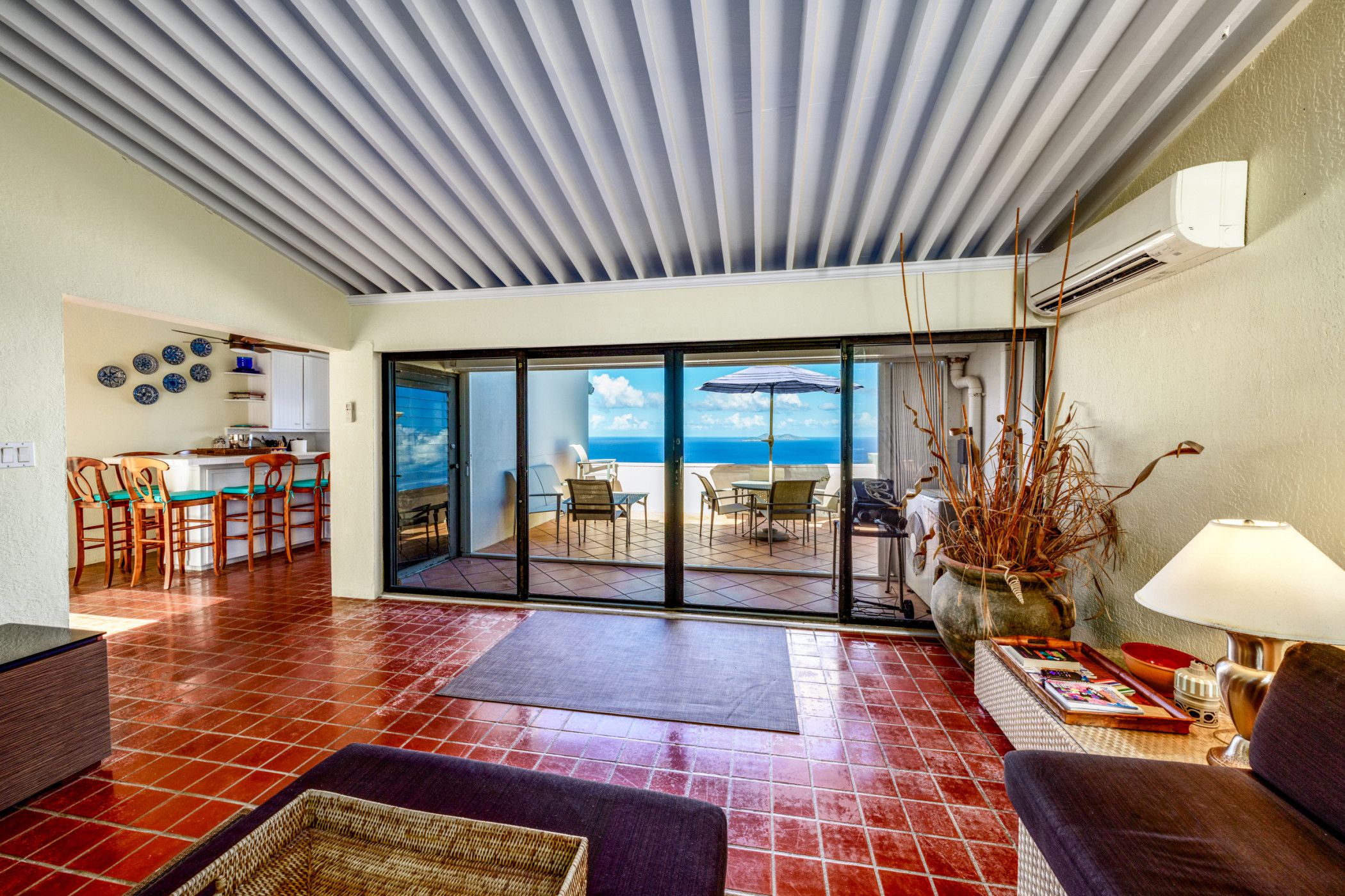 A spacious living area with a view of the sea, a dining area, and a kitchen.