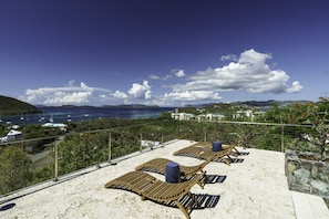 A beachside terrace with sun loungers and a view of the sea. - Vessup View · 5BR -Walk to the beach! Close to the Ritz Carlton! (St. Thomas)
