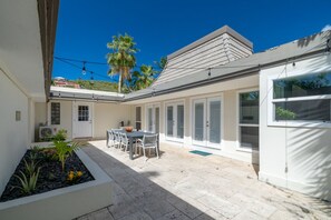 Une maison moderne dotée d’un patio, d’un coin repas et d’un garage.