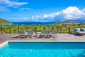 A pool area with lounge chairs and a view of the ocean and boats. - 4br w/Incredible views of St. John and the BVI - sleeps 10 (St. Thomas)