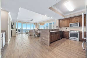 Een ruime keuken met houten vloeren, moderne apparatuur en een groot eiland.