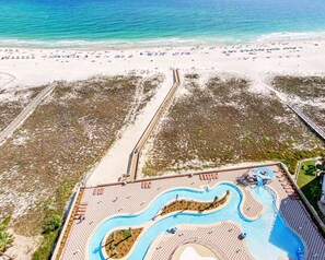 An aerial view of a resort with a beach, a swimming pool, and a boardwalk. - Phoenix OB II #801 -- Luxury 4BR Beachfront Corner Unit, VIEWS, Lazy  River (Orange Beach)