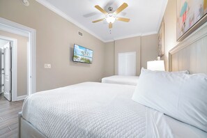A bedroom with two beds, a ceiling fan, a television, and a painting on the wall. - Phoenix OB II #801 -- Luxury 4BR Beachfront Corner Unit, VIEWS, Lazy  River (Orange Beach)