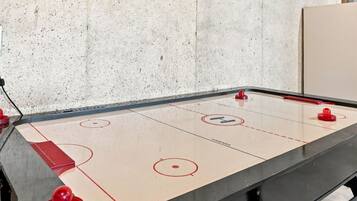 Een tafelhockeyspel met vier rode schijven en een zwarte tafel.