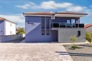 A modern villa with a flat roof, a balcony, and a paved entrance area. - Villa Azur – Modern Villa with a Swimming Pool and Jacuzzi on the Island of Krk (Hlapa (Krk))
