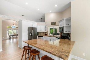 A modern kitchen with white cabinetry, granite countertops, and stainless steel appliances. - Your Peaceful Island Getaway - 3 BR/3 Bath (Marco Island)