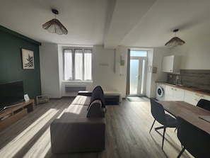 Un espacio habitable moderno con un sofá, una mesa de comedor y una cocina.