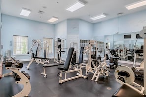 A gym with various exercise equipment, a bench, and dumbbells. - Cozy apartment only miles from Disney community pool and Jacuzzii (Kissimmee)