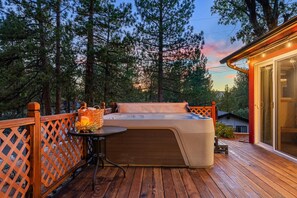 A hot tub on a wooden deck with a wooden fence and a table with a candle. - The Village Villa - Hot Tub, Walk to village (Big Bear Lake)