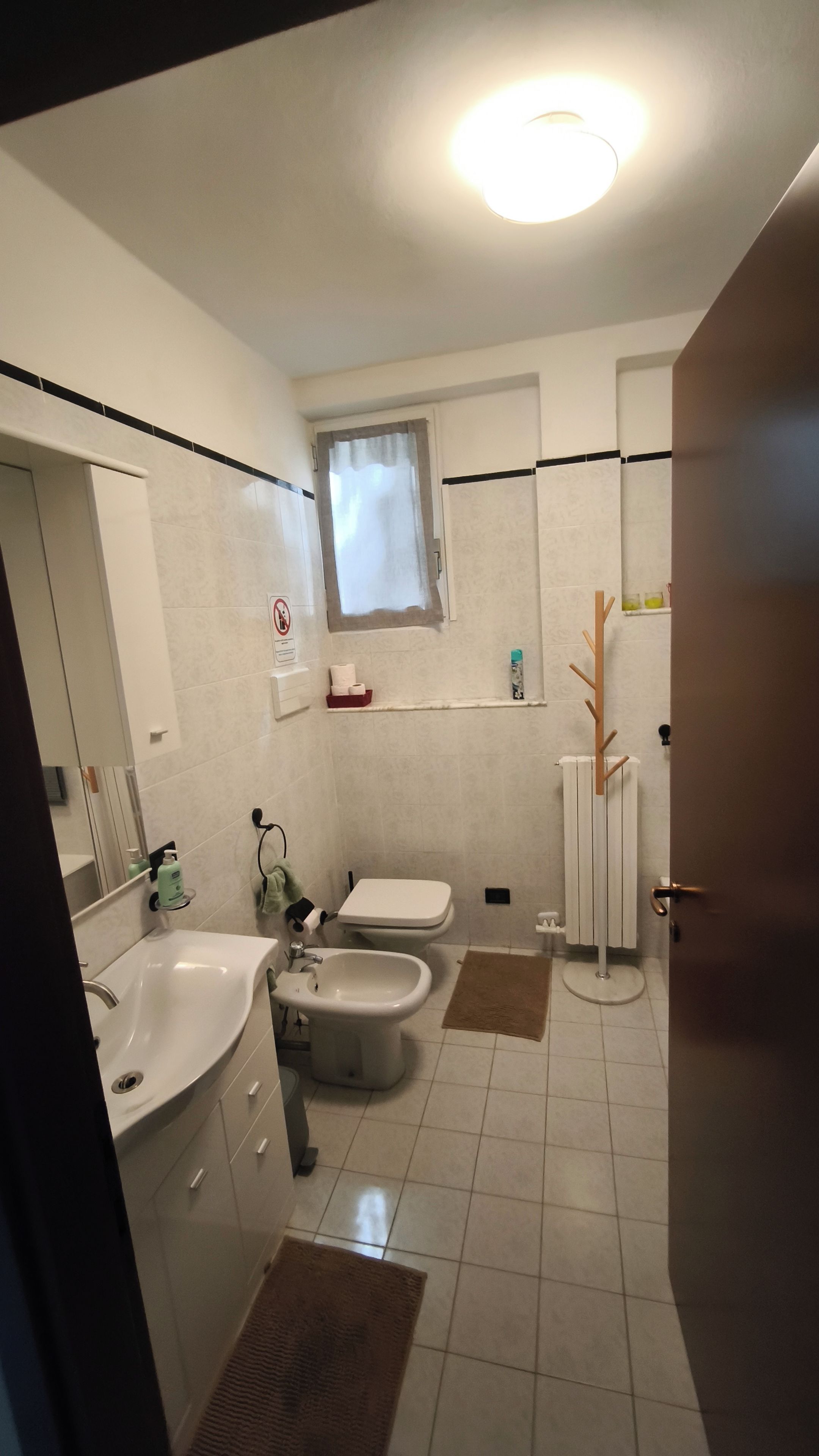 Ein Badezimmer mit Waschbecken, Bidet, Toilette und einem Fenster.