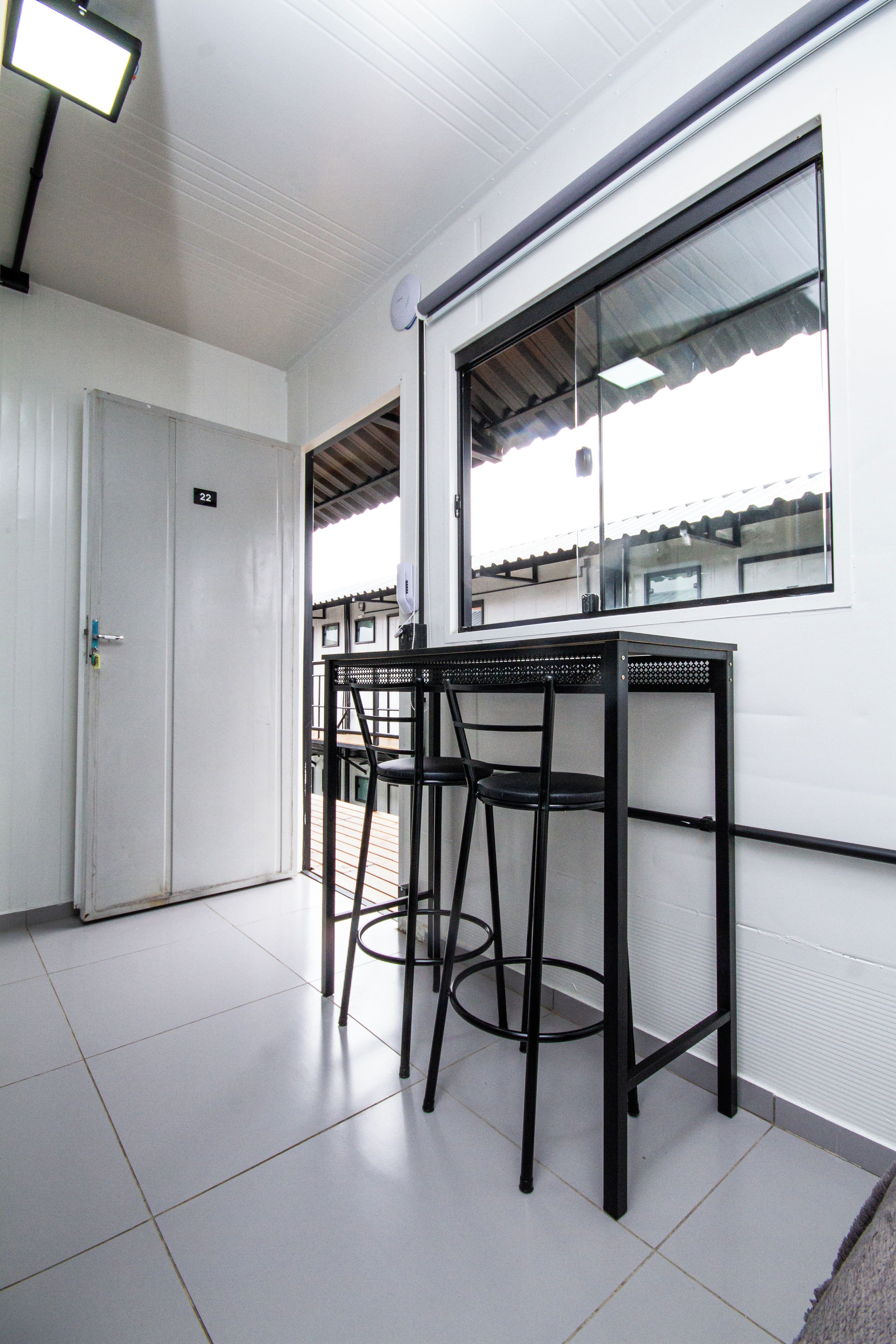 A room with a white door, a window, and a table with chairs.