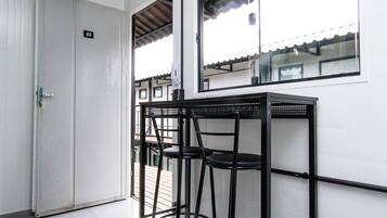 A room with a white door, a window, and a table with chairs.