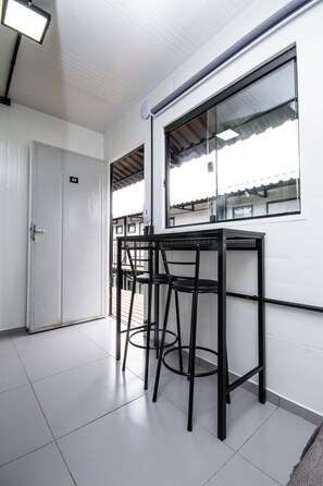 Una habitación con una puerta blanca, una ventana y una mesa con sillas.