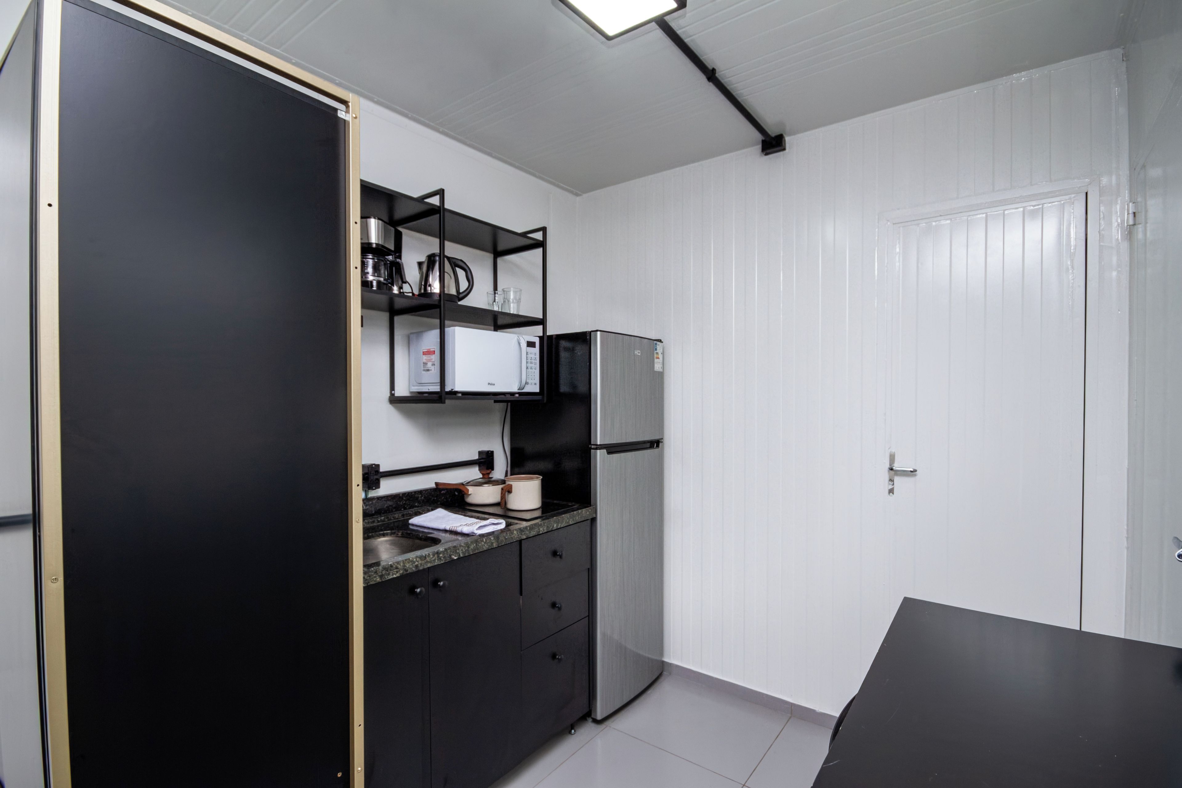 A compact kitchen with a microwave, refrigerator, and a small countertop.