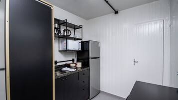 A compact kitchen with a microwave, refrigerator, and a small countertop.