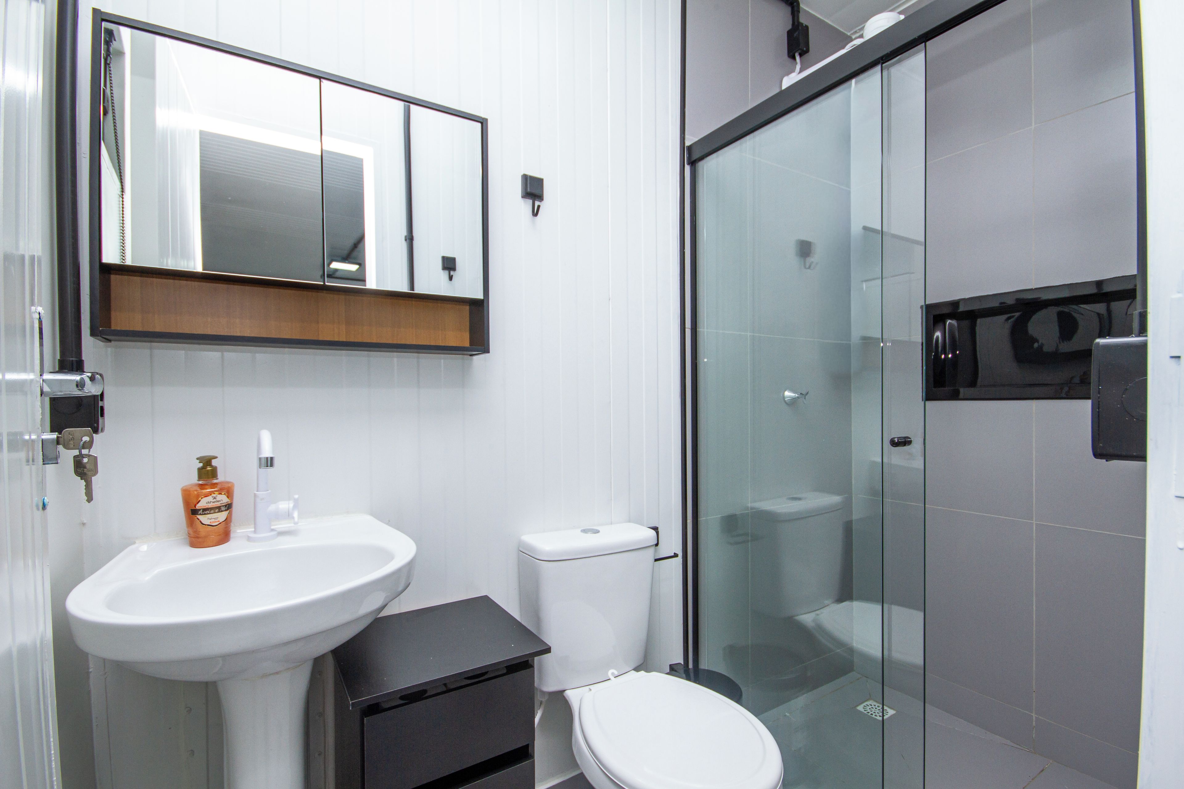 A bathroom with a white sink, a toilet, and a glass shower enclosure.