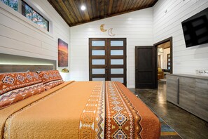 Ein Schlafzimmer mit Bett, Nachttisch, Kommode und einer Tür mit Mond- und Halbmonddekor.