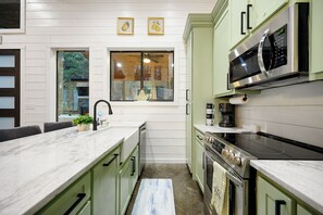 A kitchen with a marble countertop, a built-in microwave, and a stove. - Large Deck! Hot tub! HorseShoe Set! Outdoor Dining (Broken Bow)