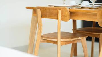 Ein Holztisch mit Stühlen, einem Glas und weißen Tellern.
