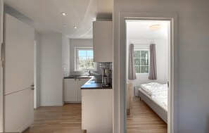 A compact bedroom with a single bed and a small kitchenette area. - 2 bedroom cozy home in Læsø (Læsø)