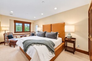A bedroom with a large bed, bedside lamps, a window with a view, and a chair. - Beaver Creek True Ski-In/Ski-Out | Private Hot Tub (Beaver Creek)