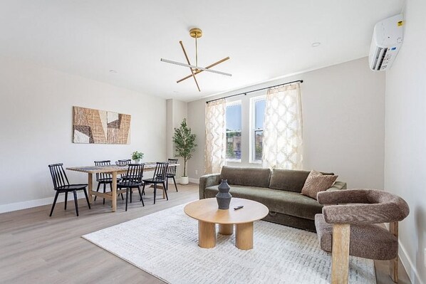A modern living room with a dining area, a sofa, and a coffee table.