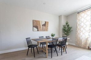 A dining area with a wooden table, black chairs, and a woven placemat.