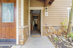 A wooden house entrance with a stone foundation, a number 7 sign, and a clear path leading to the door. - Beautiful 3Bd 4Bt townhome in Breckenridge perfect for mountain sports getaways (Breckenridge)