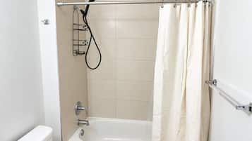 A bathroom with a bathtub, a shower head, and a curtain.