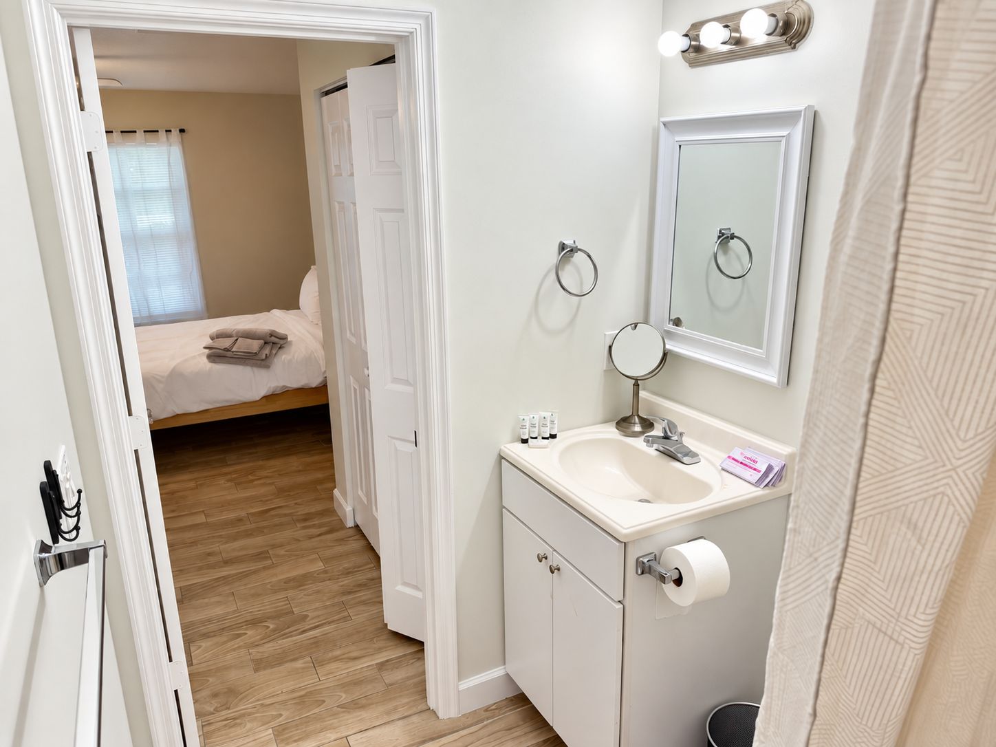 A bathroom with a sink, mirror, and toilet paper.