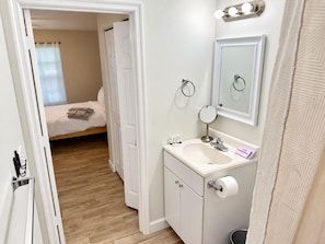 A bathroom with a sink, mirror, and toilet paper.