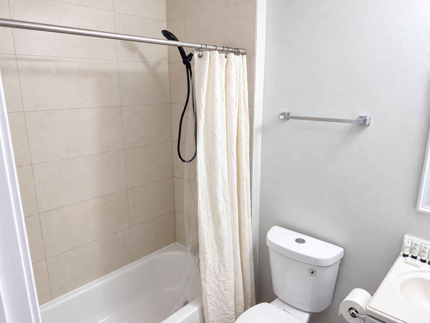 Une salle de bain avec une baignoire, des toilettes et un rideau de douche.