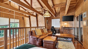 A wooden interior with a leather sofa, a television, and a desk. - Bear Pine Lodge by Avantstay Hot Tub + Firepit + Arcade Mountain Views Mins to Slopes + Lake (Big Bear City)