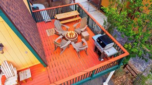 A deck with a fire pit, outdoor seating, and a grill. - Bear Pine Lodge by Avantstay Hot Tub + Firepit + Arcade Mountain Views Mins to Slopes + Lake (Big Bear City)