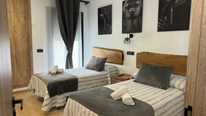A hotel room with two beds, a wooden wardrobe, and artwork on the walls. - Mirador el Llano 3 Pozo Alcón by Ruralidays (Province of Jaén)