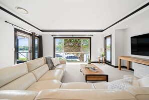Un soggiorno moderno con un divano, un tavolino da caffè e una televisione a schermo piatto.